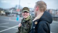 Ein Soldat läuft neben seinem Partner und lächelt ihn an