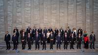 In drei Reihen stehen die Verteidigungsminister der NATO Mitgliedsländer für ein Gruppenfoto zusammen.
